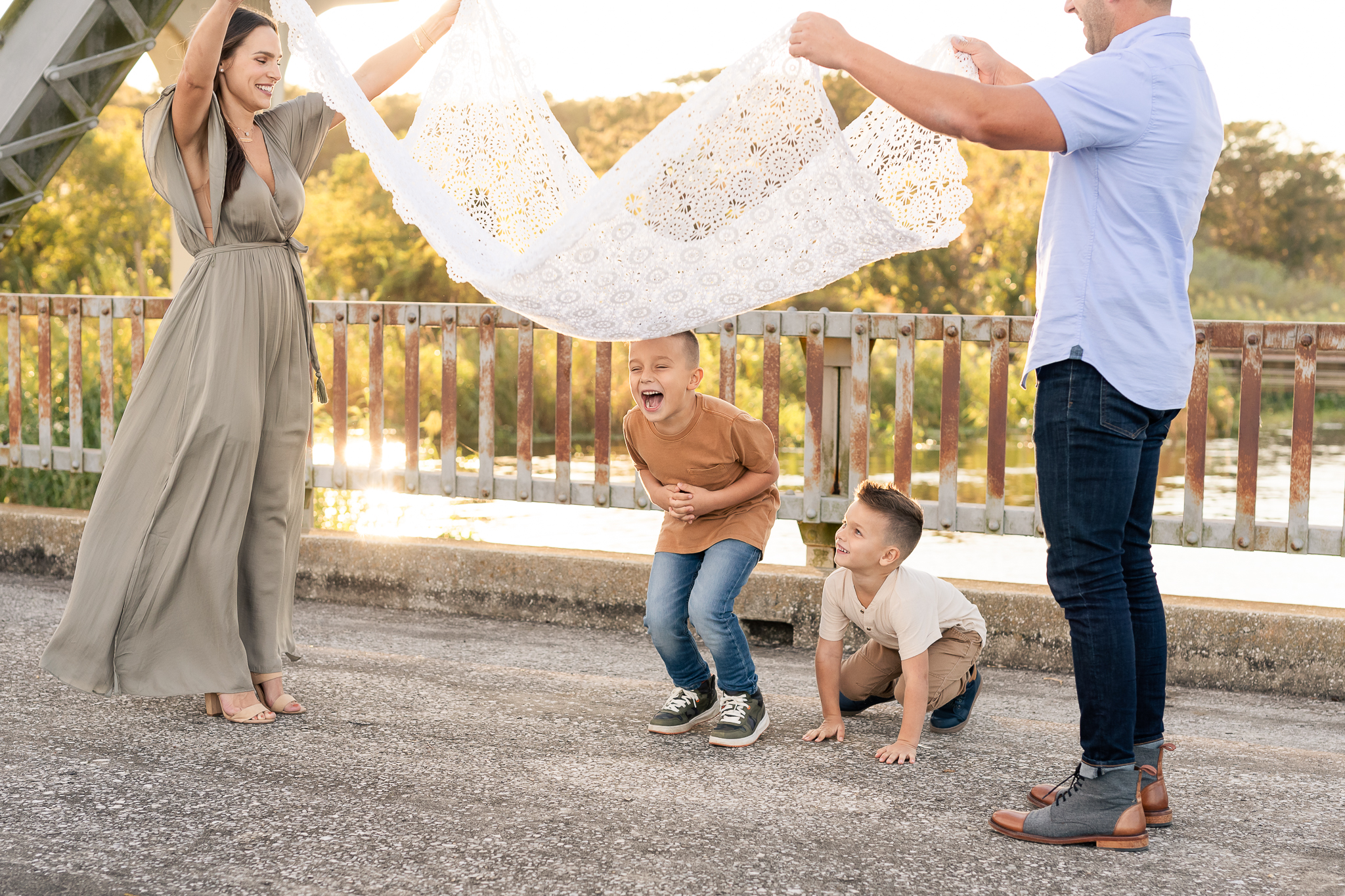 A family of four with two young children playing a game called parachute in their Fall Family Photo Session in Lake Mary, Florida. 