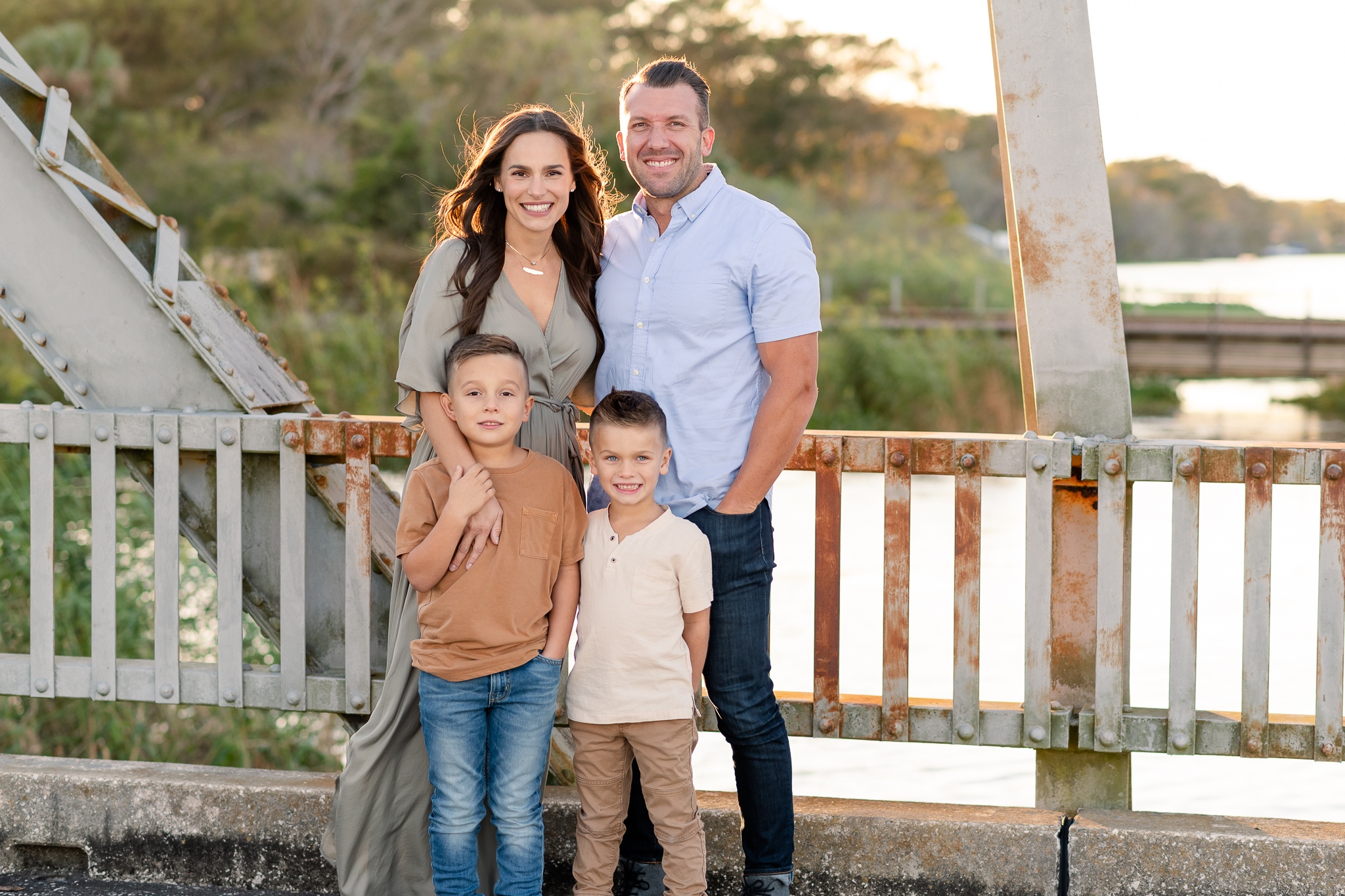 A family of four with two young children passing looking straight at the camera and smiling at their fall family photo session in Lake Mary, Florida